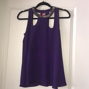 Purple blouse with gold embellishment.